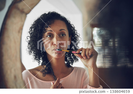 Woman, cleaning and brushing teeth in mirror, routine and oral hygiene in bathroom, grooming and health. Brazilian female, reflection and fresh breath in mouth, toothpaste and toothbrush for dental 138604659