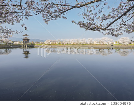 The sky and the water's surface merge, enveloped in the tranquility of spring at Karako Pond. The sky and the water's surface merge, enveloped in the tranquility of spring at Karako Pond. 138604976