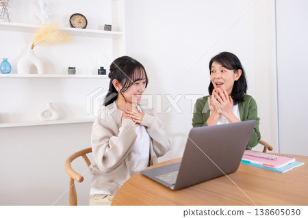 Mother and daughter find comfort in looking at the computer. Mother and daughter find comfort in looking at the computer. 138605030