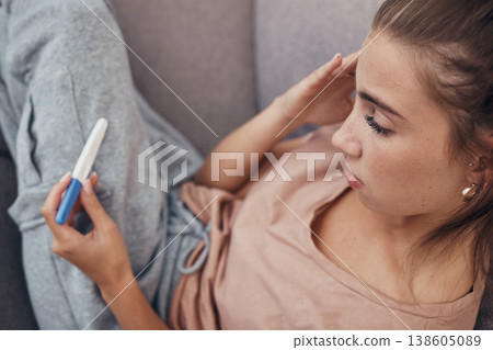 Pregnancy test, sad and woman on sofa in home, reading bad news or negative results. Stick, serious and frustrated pregnant mother depressed in living room for fail, stress or anxiety for infertility Pregnancy test, sad and woman on sofa in home, reading bad news or negative results. Stick, serious and frustrated pregnant mother depressed in living room for fail, stress or anxiety for infertility 138605089