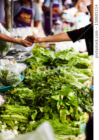 Vegetables, market and hands for payment, shopping and customer cash at local food store or outdoor vendor. Seller, supplier or small business people, giving money and lettuce, green or asian herbs Vegetables, market and hands for payment, shopping and customer cash at local food store or outdoor vendor. Seller, supplier or small business people, giving money and lettuce, green or asian herbs 138605114