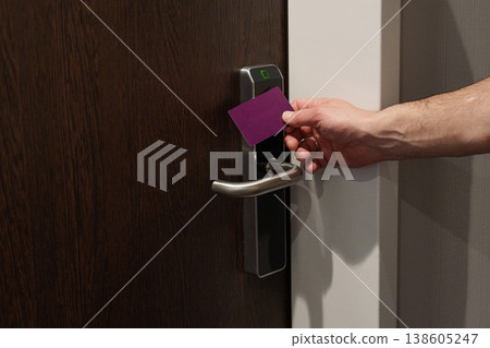 Hand using key card to unlock hotel room door Hand using key card to unlock hotel room door 138605247