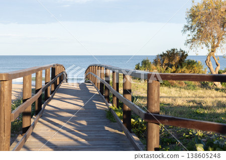 Wooden pier at sunset along the dune beach. Wooden pier at sunset along the dune beach. 138605248