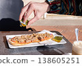 Man drizzling tostada with olive oil. Spanish breakfast. 138605251