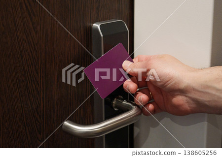 Hand holding key card near electronic door lock Hand holding key card near electronic door lock 138605256