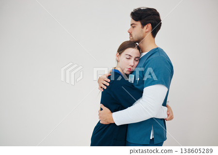 Doctor, colleagues and tired stress for support, healthcare clinic or hug. Medical professionals, friends and helping comfort in scrubs on wall background, mockup space or fatigue trust at hospital Doctor, colleagues and tired stress for support, healthcare clinic or hug. Medical professionals, friends and helping comfort in scrubs on wall background, mockup space or fatigue trust at hospital 138605289