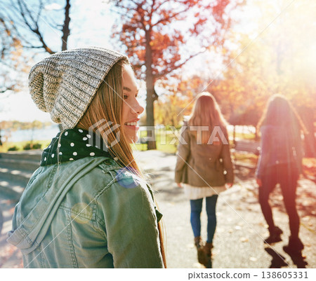 Teenage girl in nature with friends, walk in park with autumn and sunshine, wellness with happiness. Youth outdoor, enjoy fresh air and bonding with smile, lens flare with adventure or travel 138605331