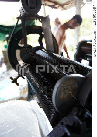 Rubber, closeup and industrial roller machine in workshop, factory and production warehouse. Manufacturing, agriculture and equipment for rolling latex, plastic and natural material on plantation Rubber, closeup and industrial roller machine in workshop, factory and production warehouse. Manufacturing, agriculture and equipment for rolling latex, plastic and natural material on plantation 138605594