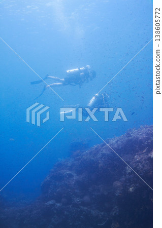 Couple, swimming and scuba diving in sea for underwater adventure and explore on tropical holiday or vacation. Sports people, tourist or diver with bubbles, blue water and search ocean life or coral 138605772