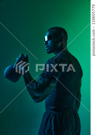 Athlete holding kettlebell showing arm strength in functional fitness workout in neon space Athlete holding kettlebell showing arm strength in functional fitness workout in neon space 138605779