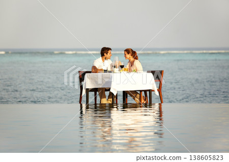 Romantic, happy and a couple at the beach for dinner in the ocean, conversation and a date. Smile, love and a man and woman with lunch, breakfast or eating in the water of the sea on a holiday Romantic, happy and a couple at the beach for dinner in the ocean, conversation and a date. Smile, love and a man and woman with lunch, breakfast or eating in the water of the sea on a holiday 138605823