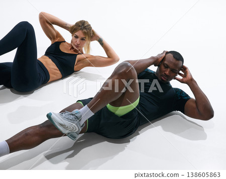Fit man and woman doing abdominal crunch exercise close up isolated on white 138605863