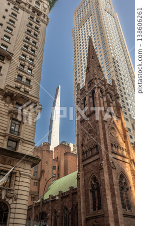 New york, usa august 14,2024. Fifth avenue presbyterian church spire rising against glass and steel skyscrapers under a clear blue midtown manhattan sky 138606261