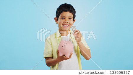 Piggy bank, cash and child face with money, savings and cash planning in a studio, Happy, portrait and young boy with allowance and safe for bills, wealth and budget with blue background and smile Piggy bank, cash and child face with money, savings and cash planning in a studio, Happy, portrait and young boy with allowance and safe for bills, wealth and budget with blue background and smile 138606357