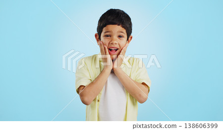 Smile, kid and hands on face for surprise in studio isolated on a blue background mockup space. Portrait, wow and happy child shocked at good news, promo announcement and excited facial expression Smile, kid and hands on face for surprise in studio isolated on a blue background mockup space. Portrait, wow and happy child shocked at good news, promo announcement and excited facial expression 138606399