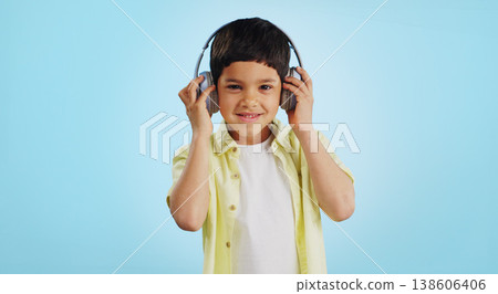 Kid, dancing and listening to music in studio with smile on blue background in mockup for fun, promotion and summer. Youth, boy or person with headphones for app, streaming or game on social media Kid, dancing and listening to music in studio with smile on blue background in mockup for fun, promotion and summer. Youth, boy or person with headphones for app, streaming or game on social media 138606406