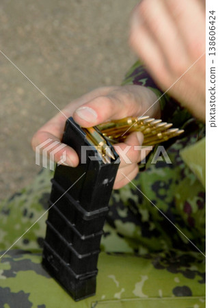 Rifle, soldier hands and bullet for gun outdoor with military training, battle and conflict. Army, war and field with a male tactical expert of a hero with weapon for shooting range and warrior gear 138606424