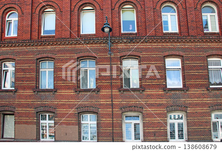 Building with many windows. Urban scene. City life. old red brick building 138608679