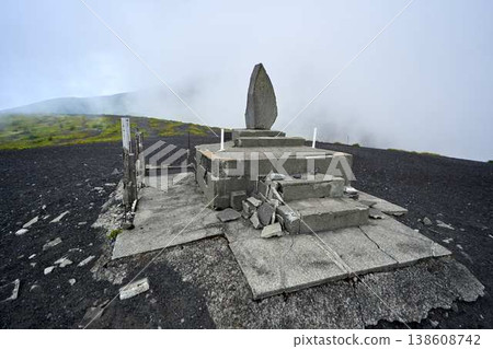 富士山禦殿場登山道上的石碑和荒涼的火山景觀(靠近霧氣瀰漫的山頂)。 富士山禦殿場登山道上的石碑和荒涼的火山景觀(靠近霧氣瀰漫的山頂)。 138608742