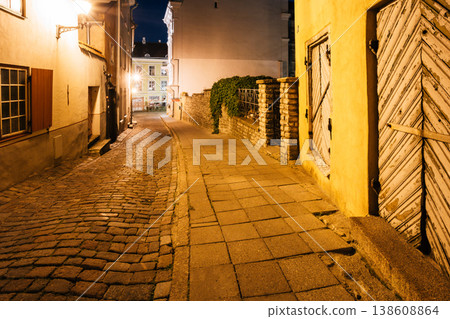 Narrow Illuminated Cobblestone Street in Tallinn at Night 138608864