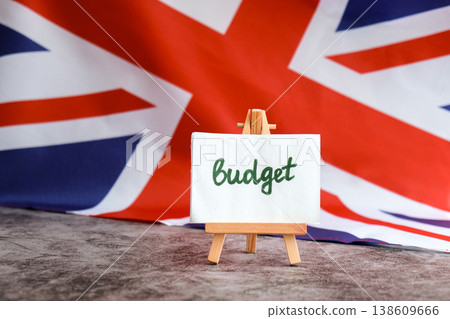 Paper note with words BUDGET on National symbol of Great Britain. British wave the UK silky flag background. Economy federal annual finance planning Paper note with words BUDGET on National symbol of Great Britain. British wave the UK silky flag background. Economy federal annual finance planning 138609666