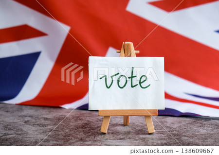Paper note with words VOTE on National symbol of Great Britain. British wave the UK silky flag background. Ellection political participation campaign and civic engagement Paper note with words VOTE on National symbol of Great Britain. British wave the UK silky flag background. Ellection political participation campaign and civic engagement 138609667