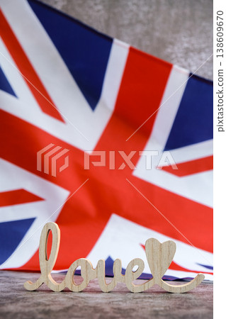 Wooden word love on National symbol of Great Britain. British full framed wave UK fabric flag background. Copy space for your text. Independence Wooden word love on National symbol of Great Britain. British full framed wave UK fabric flag background. Copy space for your text. Independence 138609670