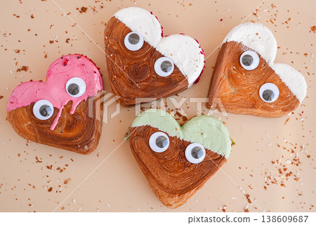 Funny food game face with crazy eyes April fool day joke Delightful and vibrant heartshaped pastry croissant treat, beautifully topped with colorful frosting galore. Food experimentation dessert Funny food game face with crazy eyes April fool day joke Delightful and vibrant heartshaped pastry croissant treat, beautifully topped with colorful frosting galore. Food experimentation dessert 138609687