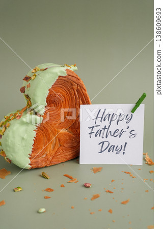 HAPPY FATHER'S DAY saying note present gift Heart shaped pistachio croissant on green background with copy space. Puff pastry trendy sweet dessert bakery. Creamy dough experiment  138609693