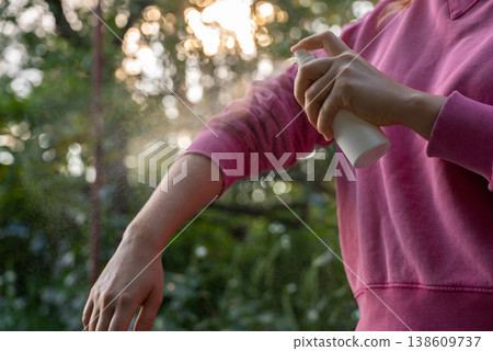 Hand applying insect repellent mosquito insecticide spray to kill flies bugs and mosquitoes on skin outside. Malaria zika virus and dengue fever prevention Hand applying insect repellent mosquito insecticide spray to kill flies bugs and mosquitoes on skin outside. Malaria zika virus and dengue fever prevention 138609737