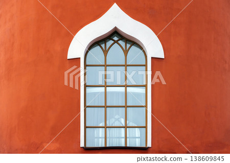 An ornate arched window with white trim An ornate arched window with white trim 138609845