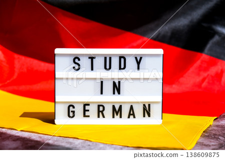 Lightbox with text STUDY IN GERMAN National symbol of Germany. German wave silky flag background. Education and learning  138609875