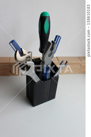 Variety Home Tools With Colored Handles Stacked In Plastic Box On White Shelf At Workshop Variety Home Tools With Colored Handles Stacked In Plastic Box On White Shelf At Workshop 138610183