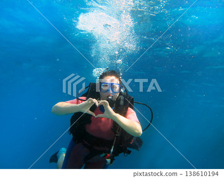 Woman scuba diving making heart gesture underwater Woman scuba diving making heart gesture underwater 138610194