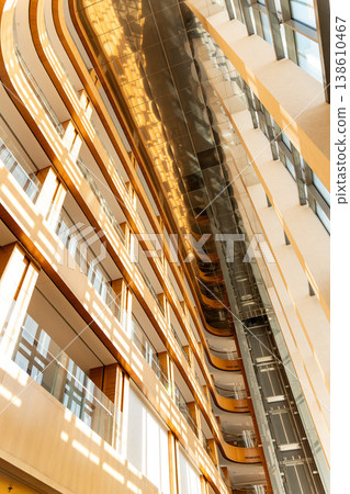 Modern multi-story atrium with curved wooden balconies Modern multi-story atrium with curved wooden balconies 138610467