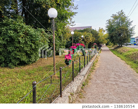 Park pathway with decorative lights and flower beds along the edge 138610554