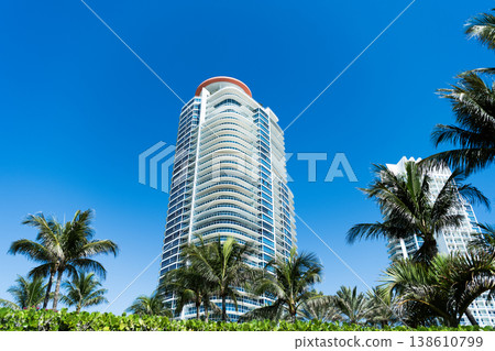 Skyscraper with palm tree. City architecture. Architecture of modern residential building. Perspective city skyscraper. Modern skyscraper building. Architectural building in Miami south beach Skyscraper with palm tree. City architecture. Architecture of modern residential building. Perspective city skyscraper. Modern skyscraper building. Architectural building in Miami south beach 138610799