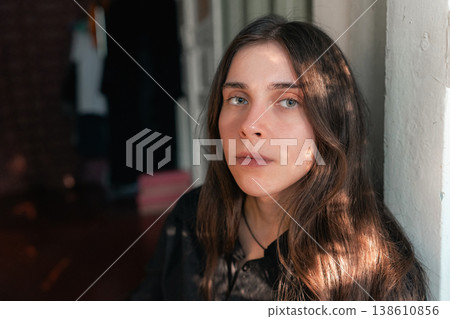 Young woman portrait by wall in soft natural indoor light Young woman portrait by wall in soft natural indoor light 138610856