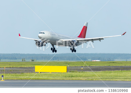 Big wide body passenger airplane landing on an airport runway Big wide body passenger airplane landing on an airport runway 138610998