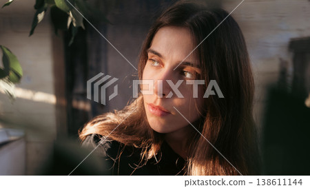 Natural outdoor portrait of thoughtful young woman in sunlight Natural outdoor portrait of thoughtful young woman in sunlight 138611144