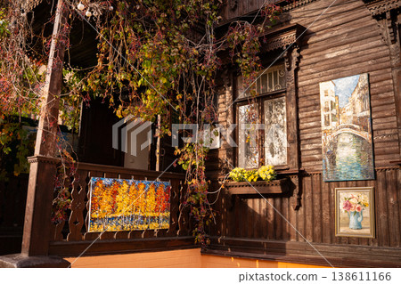 Rustic Wooden House Porch with Paintings and Autumn Vines 138611166