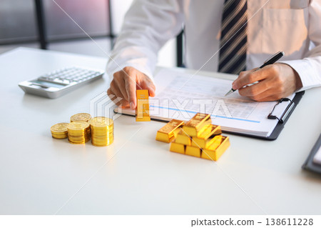 Gold Trading Businessman invest in trading gold, calculating profit price of buy and sell gold. 138611228