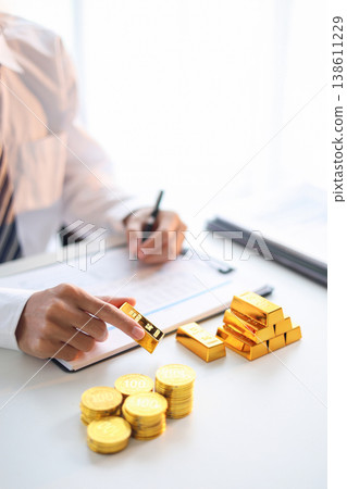 Gold Trading Businessman invest in trading gold, calculating profit price of buy and sell gold. 138611229