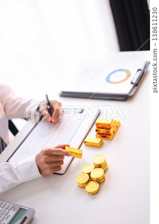 Gold Trading Businessman invest in trading gold, calculating profit price of buy and sell gold. 138611230