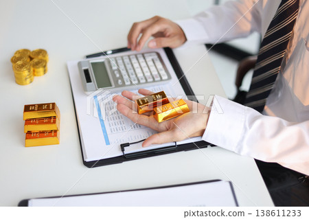 Gold Trading Businessman invest in trading gold, calculating profit price of buy and sell gold. Gold Trading Businessman invest in trading gold, calculating profit price of buy and sell gold. 138611233