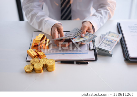 Businessman investing in gold. Strategy for businesspeople and institutional investors to diversify portfolios, hedge against inflation and currency depreciation Businessman investing in gold. Strategy for businesspeople and institutional investors to diversify portfolios, hedge against inflation and currency depreciation 138611265