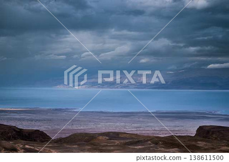 Dramatic desert landscape with mountains and storm clouds over arid valley Dramatic desert landscape with mountains and storm clouds over arid valley 138611500