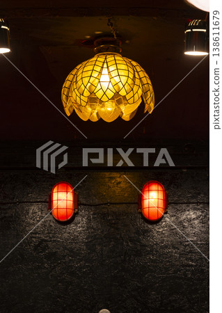 Hanging decorative lamp illuminating dark wall with red security lights Hanging decorative lamp illuminating dark wall with red security lights 138611679