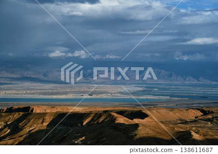 Dramatic desert coastline landscape with storm clouds over calm sea 138611687