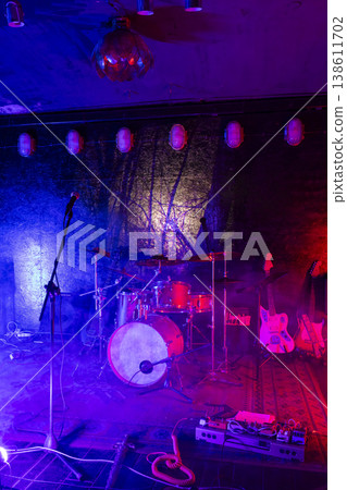 Concert stage with drums and guitars under colorful lighting Concert stage with drums and guitars under colorful lighting 138611702